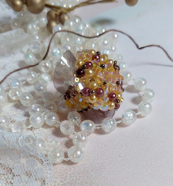 Bague Soleil mont&eacute;e avec des toupies en Cristal de Swarovski aux couleurs Topaze, Gold et Marron &agrave; laquelle s&rsquo;ajoute des facettes en Verre de Boh&egrave;me. Les perles s&rsquo;entrelacent avec les rocailles Dor&eacute;es