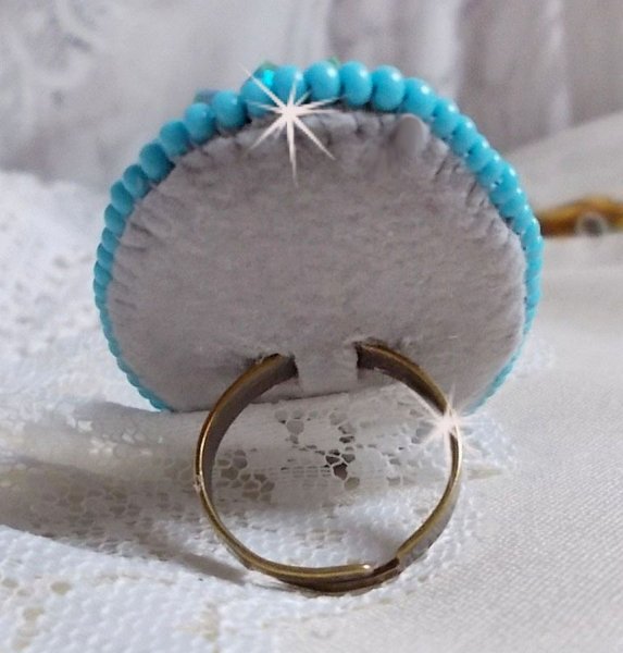 Bague Turquoise au style Am&eacute;rindien avec un cabochon ovale en pierre de gemme : le Turquoise lui-m&ecirc;me orn&eacute; de toupies en Cristal, s&rsquo;ajoute des rocailles en verre Miyuki et tch&egrave;que sur une bague Bronze