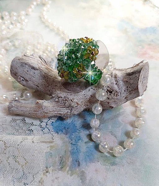 Bague Vert Tendre mont&eacute;e avec des toupies en Cristal dans les nuances de Vert Emerald et Jaune &agrave; laquelle s'ajoute des facettes et des rocailles. Un feuillage verdoyant de fleurs