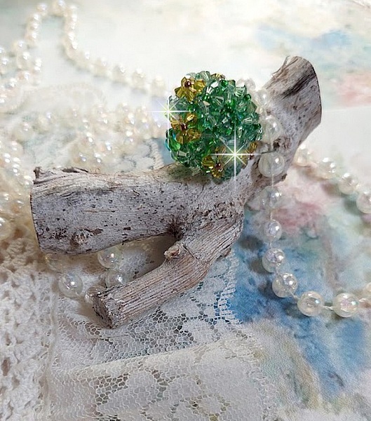 Bague Vert Tendre mont&eacute;e avec des toupies en Cristal dans les nuances de Vert Emerald et Jaune &agrave; laquelle s'ajoute des facettes et des rocailles. Un feuillage verdoyant de fleurs