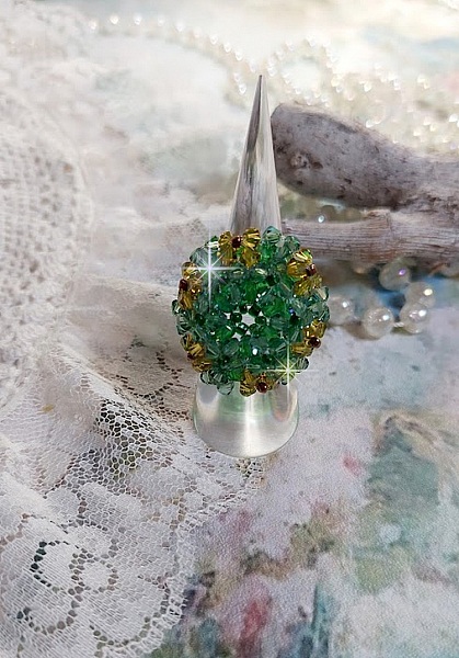 Bague Vert Tendre mont&eacute;e avec des toupies en Cristal dans les nuances de Vert Emerald et Jaune &agrave; laquelle s'ajoute des facettes et des rocailles. Un feuillage verdoyant de fleurs