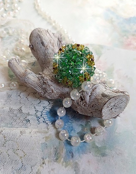 Bague Vert Tendre mont&eacute;e avec des toupies en Cristal dans les nuances de Vert Emerald et Jaune &agrave; laquelle s'ajoute des facettes et des rocailles. Un feuillage verdoyant de fleurs