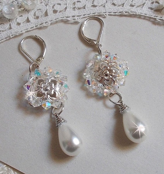 BO Gouttelettes givr&eacute;es aux gouttes Blanches de Majorque avec des estampes &agrave; laquelle s&rsquo;ajoute des toupies en Cristal AB. Le tout est mont&eacute; sur des dormeuses en Argent 925/1000 pour un style moderne