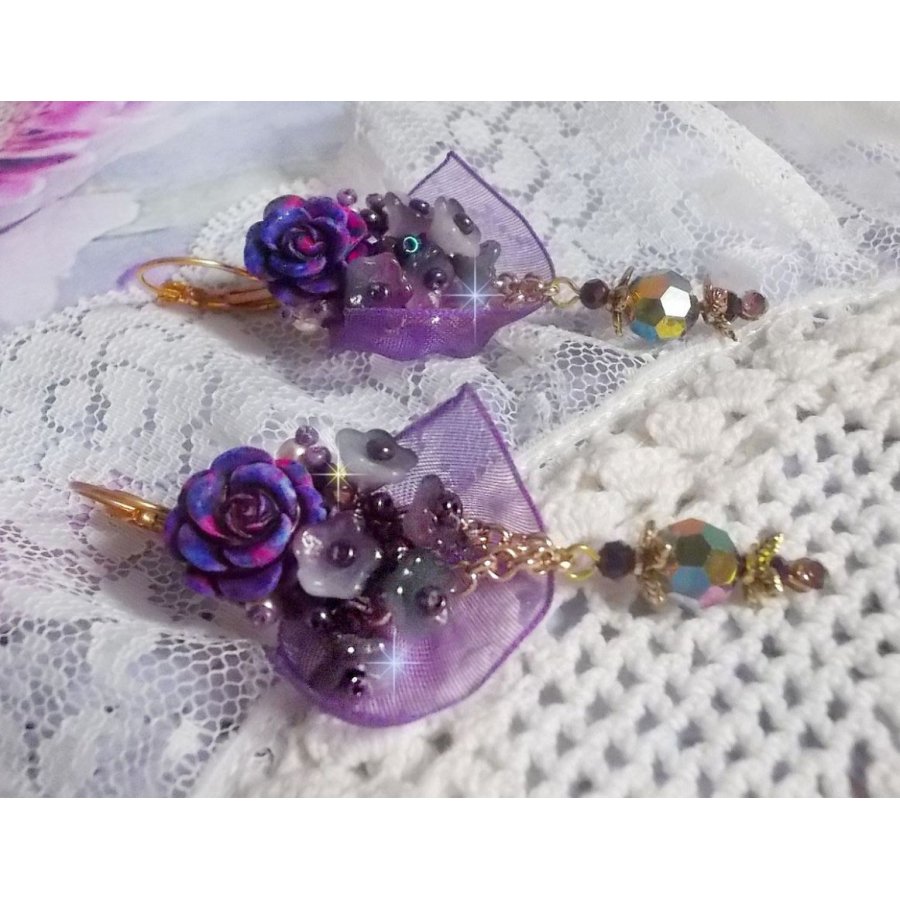 BO Lady Romantique brodées sur un ruban organza Violet : fleurs en verre, rocailles, roses en résine Rose/Fuchsia sur des dormeuses. Les pendants en cristal affinent les boucles pour une belle Lady