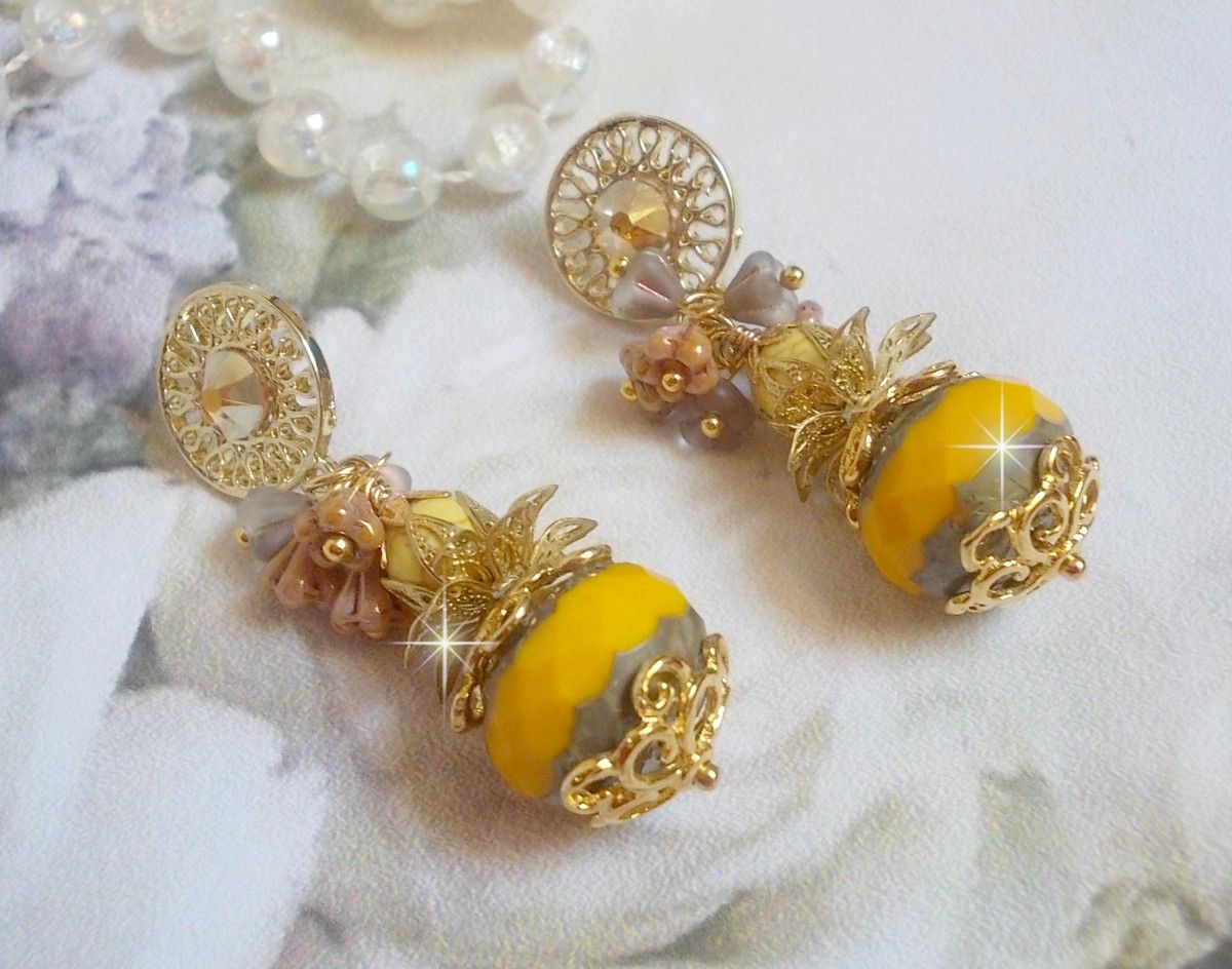 BO Lumière Opale Jaune avec des perles potirons jaunes à laquelle s’ajoute des fleurs, cabochons en cristal, coupelles et perles rondes. Montés sur clous d’oreilles en Métal. Un style moderne