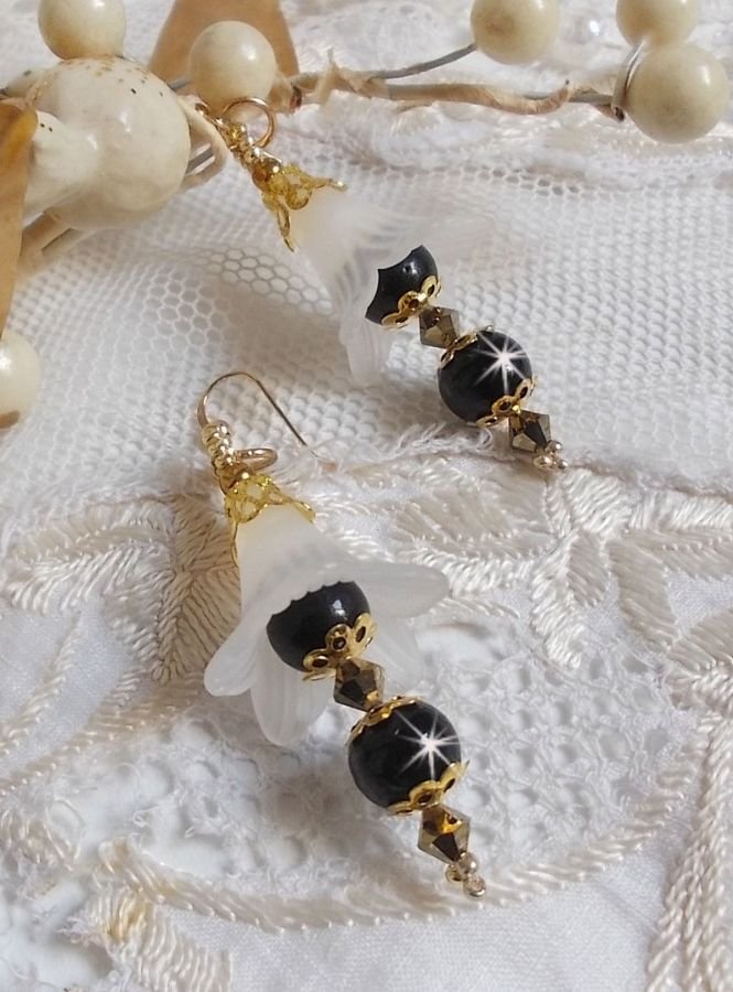 BO Passion montées avec des fleurs Lucites blanches effet givré, perles rondes céramiques de couleur Noire, coupelles, rocailles, perles boules Dorées et toupies Crystal Dorado.