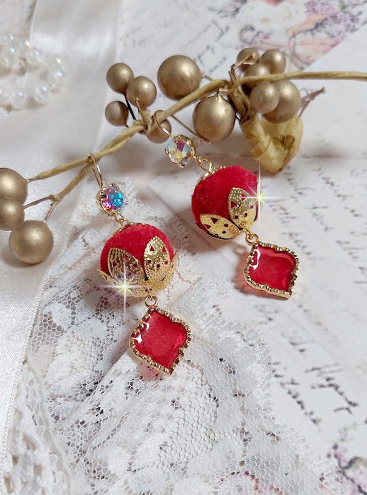 BO Passionnément montées avec des pompons Rouges très tendances à laquelle s’ajoute des coupelles en forme d’arabesque, pendentifs vitrail Rouge/Doré et cabochons en Cristal AB sur crochets en Laiton