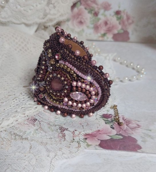 Bracelet Belle romance brod&eacute; avec des disques en Nacres Acajou et Prune. Orn&eacute; de facettes, chatons, rocailles et navettes en Cristal. Le bord du bracelet est fini avec des perles Rose et Marron