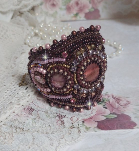 Bracelet Belle romance brod&eacute; avec des disques en Nacres Acajou et Prune. Orn&eacute; de facettes, chatons, rocailles et navettes en Cristal. Le bord du bracelet est fini avec des perles Rose et Marron
