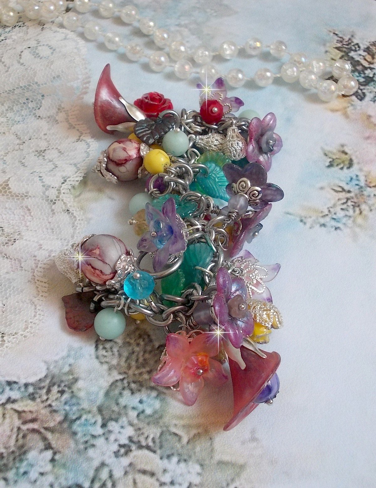 Bracelet Lady Luxe monté avec des perles de gemme : L’Amazonite et la Sugilite à laquelle s’ajoute des fleurs de différentes variétés peintes à la main : lucite et résine, breloques et perles