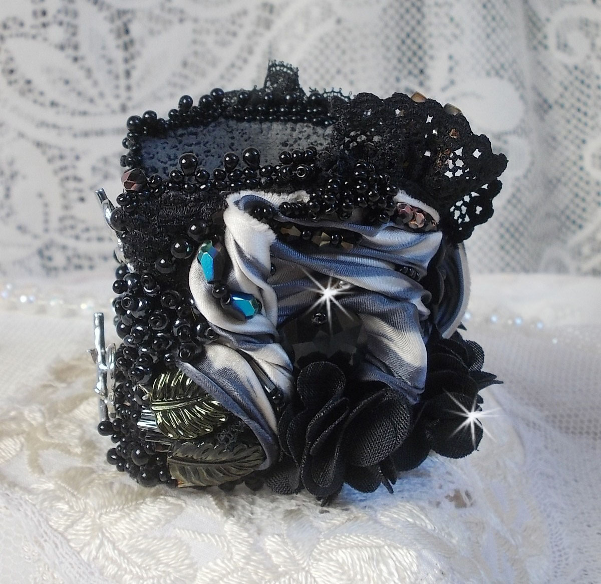 Bracelet manchette Féerie Black avec une soie grise, blanche et noir.