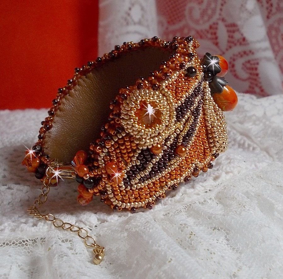 Bracelet Lady in Orange manchette Haute Couture brodé sur cuir avec cabochons en cristal, facettes, gouttes, perles nacrées, rocailles aux couleurs Orange, Jaune, Or, Marron pour un style contemporain
