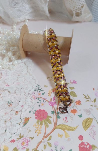 Bracelet Soleil mont&eacute; avec des facettes en verre de boh&egrave;me aux couleurs Topaze AB &agrave; laquelle s&rsquo;ajoute des perles rondes nacr&eacute;es Gold et Maron o&ugrave; elles s&rsquo;entrelacent avec les rocailles Dor&eacute;es satin&eacute;es