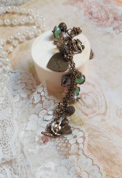 Bracelet Temps d&rsquo;une Folie avec breloques : c&oelig;ur, perles, gouttes filigran&eacute;es, fleurs &eacute;maill&eacute;es, perles rondes, cabochons carr&eacute;s et perles rondes en Verre. Mont&eacute;s sur cha&icirc;nes et fermoir en T Bronze