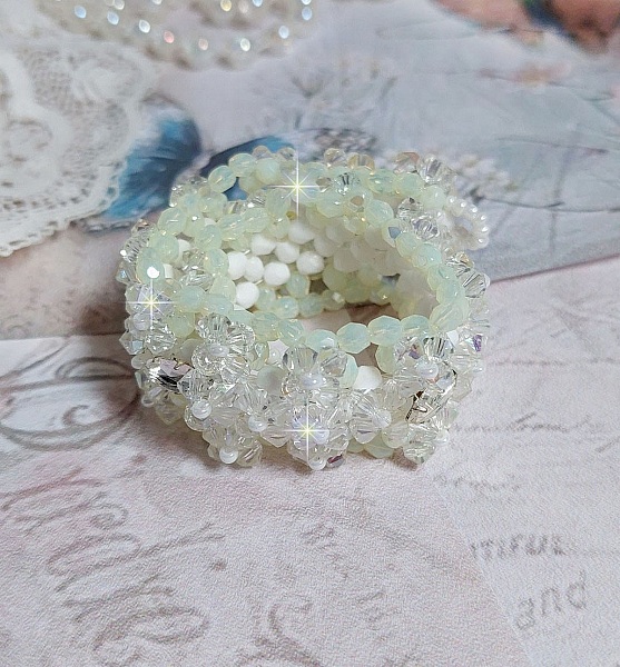 Bracelet V&eacute;nus mont&eacute; avec une cascade de cristaux : toupies et navettes en Cristal AB ainsi que les facettes de couleur Blanche et Beige Opaque de qualit&eacute; AB, puis perl&eacute; de rocailles nacr&eacute;es 