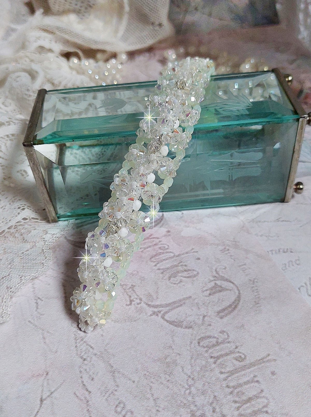 Bracelet V&eacute;nus mont&eacute; avec une cascade de cristaux : toupies et navettes en Cristal AB ainsi que les facettes de couleur Blanche et Beige Opaque de qualit&eacute; AB, puis perl&eacute; de rocailles nacr&eacute;es 