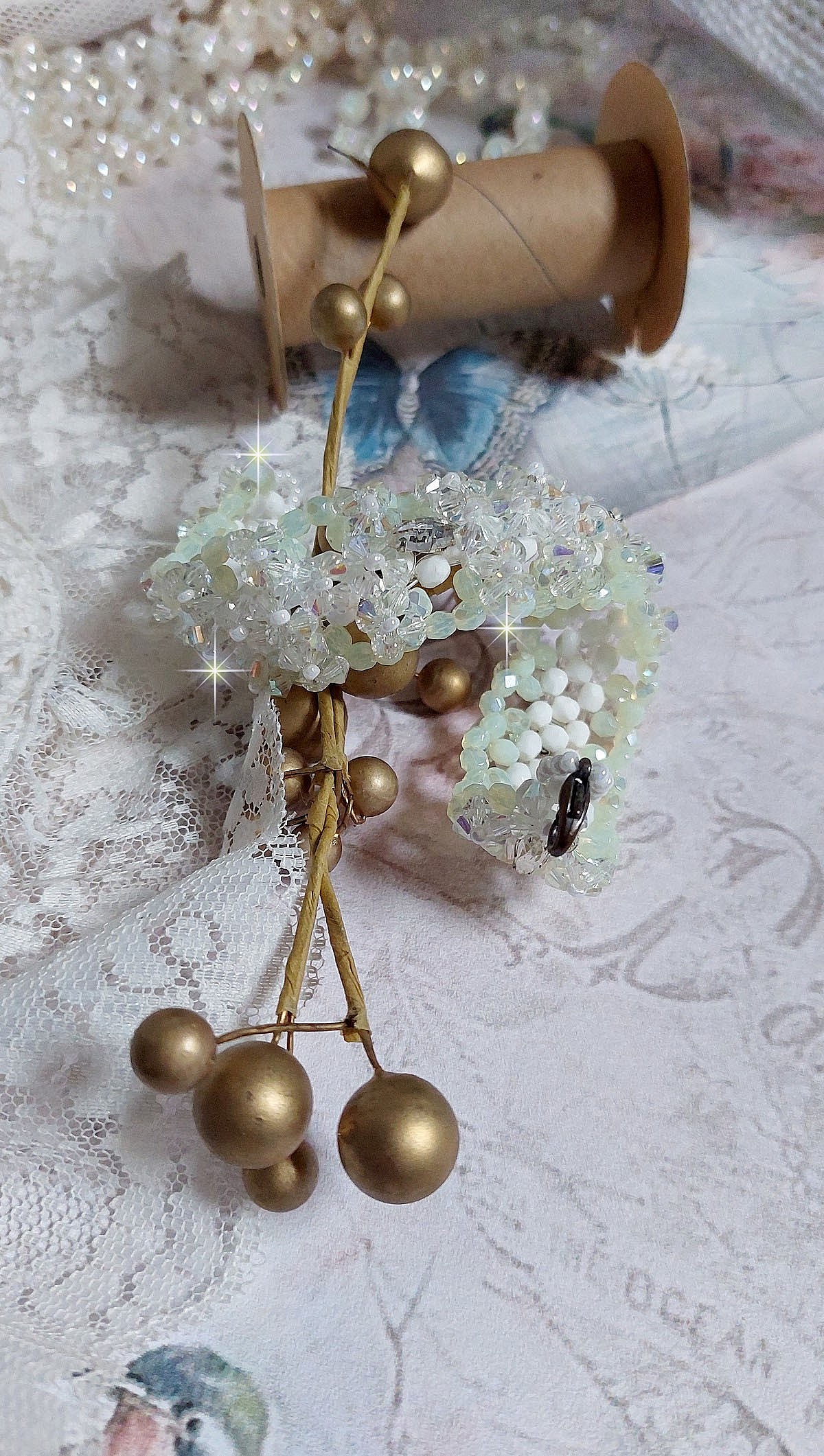 Bracelet V&eacute;nus mont&eacute; avec une cascade de cristaux : toupies et navettes en Cristal AB ainsi que les facettes de couleur Blanche et Beige Opaque de qualit&eacute; AB, puis perl&eacute; de rocailles nacr&eacute;es 