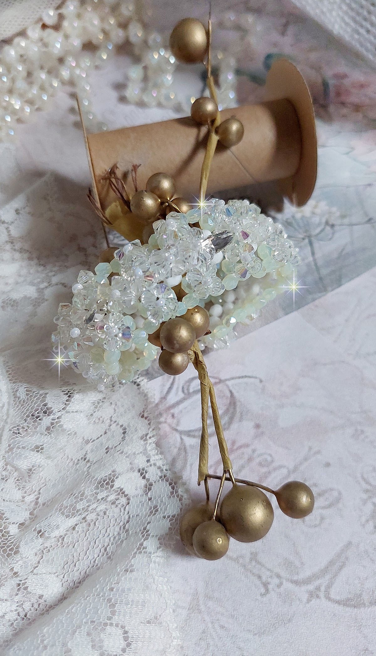 Bracelet V&eacute;nus mont&eacute; avec une cascade de cristaux : toupies et navettes en Cristal AB ainsi que les facettes de couleur Blanche et Beige Opaque de qualit&eacute; AB, puis perl&eacute; de rocailles nacr&eacute;es 