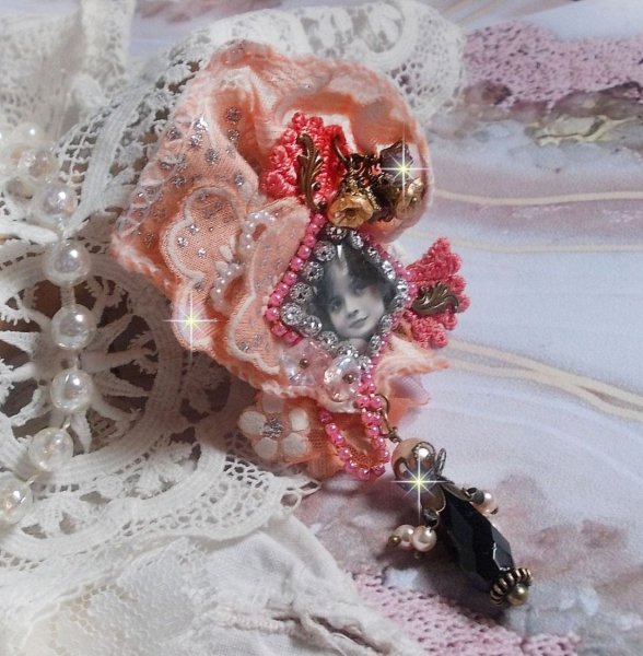 Broche Rustic Rose cr&eacute;e avec un cabochon repr&eacute;sentant une jeune fille souriante, de la dentelle Orange strass&eacute; et Rose, des cristaux, des perles en verre et des accessoires divers