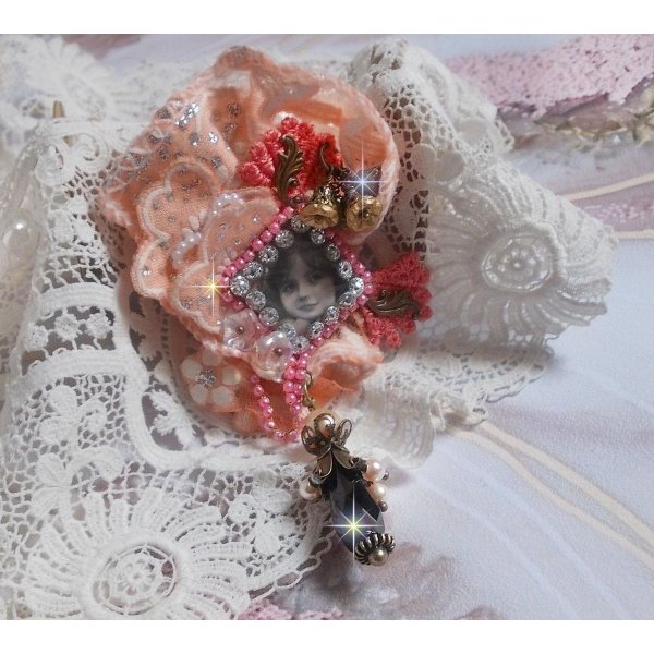 Broche Rustic Rose cr&eacute;e avec un cabochon repr&eacute;sentant une jeune fille souriante, de la dentelle Orange strass&eacute; et Rose, des cristaux, des perles en verre et des accessoires divers