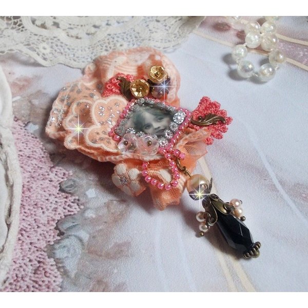 Broche Rustic Rose cr&eacute;e avec un cabochon repr&eacute;sentant une jeune fille souriante, de la dentelle Orange strass&eacute; et Rose, des cristaux, des perles en verre et des accessoires divers