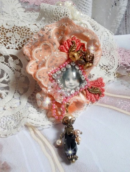 Broche Rustic Rose cr&eacute;e avec un cabochon repr&eacute;sentant une jeune fille souriante, de la dentelle Orange strass&eacute; et Rose, des cristaux, des perles en verre et des accessoires divers