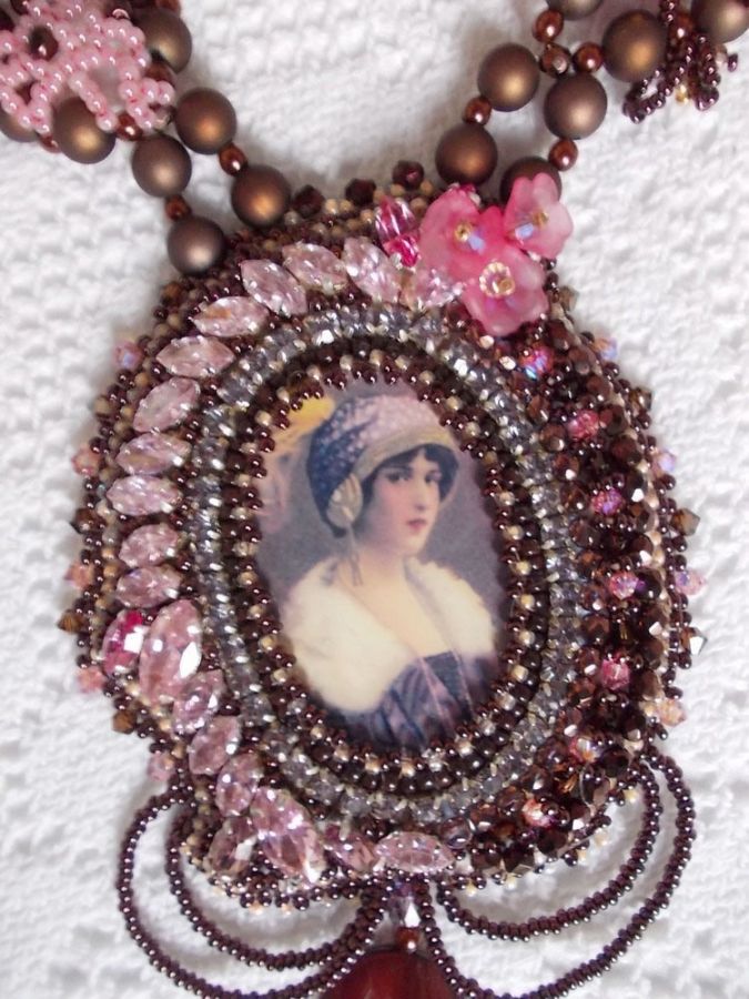 Collier Belle Romance Haute-Couture brodé avec un cabochon portrait de femme en chapeau avec des cristaux, des perles satinées, des perles rondes dorées, des perles nacrées, des cabochons en nacre et 