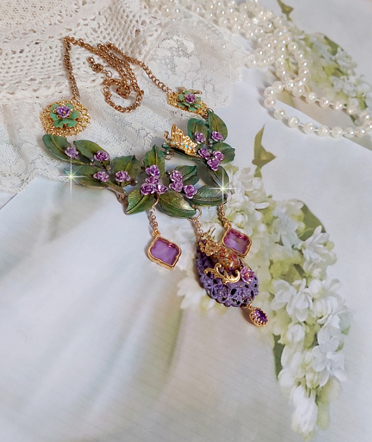 Collier Camélia Japonica monté avec un motif feuilles aquarellés à la main, paillettes, breloques papillons et abeille, roses métal, cabochon cristal, pendentifs époxy aux couleurs d’arc en ciel