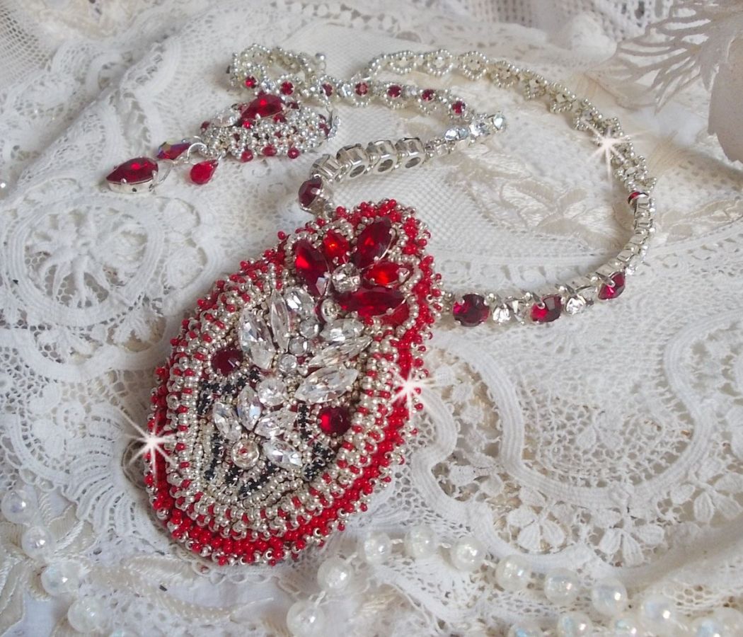 Collier Drigon Red brodé avec des cristaux de Swarovski de couleur rouge, des rocailles argentées, des strass, des fermoirs et des chaînettes en argent 925/1000