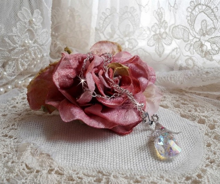 Sur une rose, le collier brille par ces éclats de cristaux