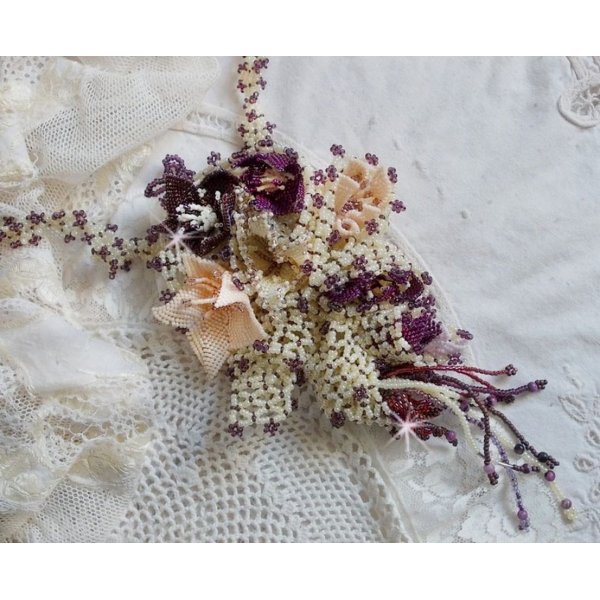 Collier Les Floralies sur une base Netting, j&rsquo;ai r&eacute;alis&eacute; &agrave; l&rsquo;aiguille un bouquet de fleurs et feuilles en rocailles &agrave; laquelle s&rsquo;ajoute des Sugilites. Aux couleurs Ivoire, Am&eacute;thyste, Rose et Purple