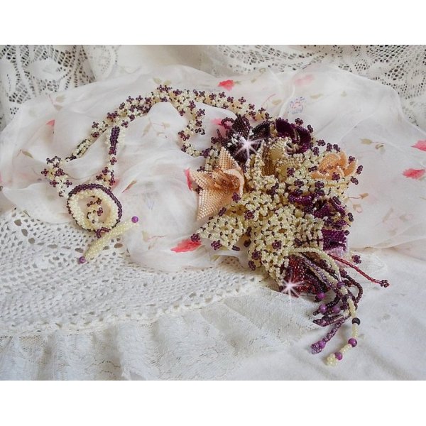 Collier Les Floralies sur une base Netting, j&rsquo;ai r&eacute;alis&eacute; &agrave; l&rsquo;aiguille un bouquet de fleurs et feuilles en rocailles &agrave; laquelle s&rsquo;ajoute des Sugilites. Aux couleurs Ivoire, Am&eacute;thyste, Rose et Purple