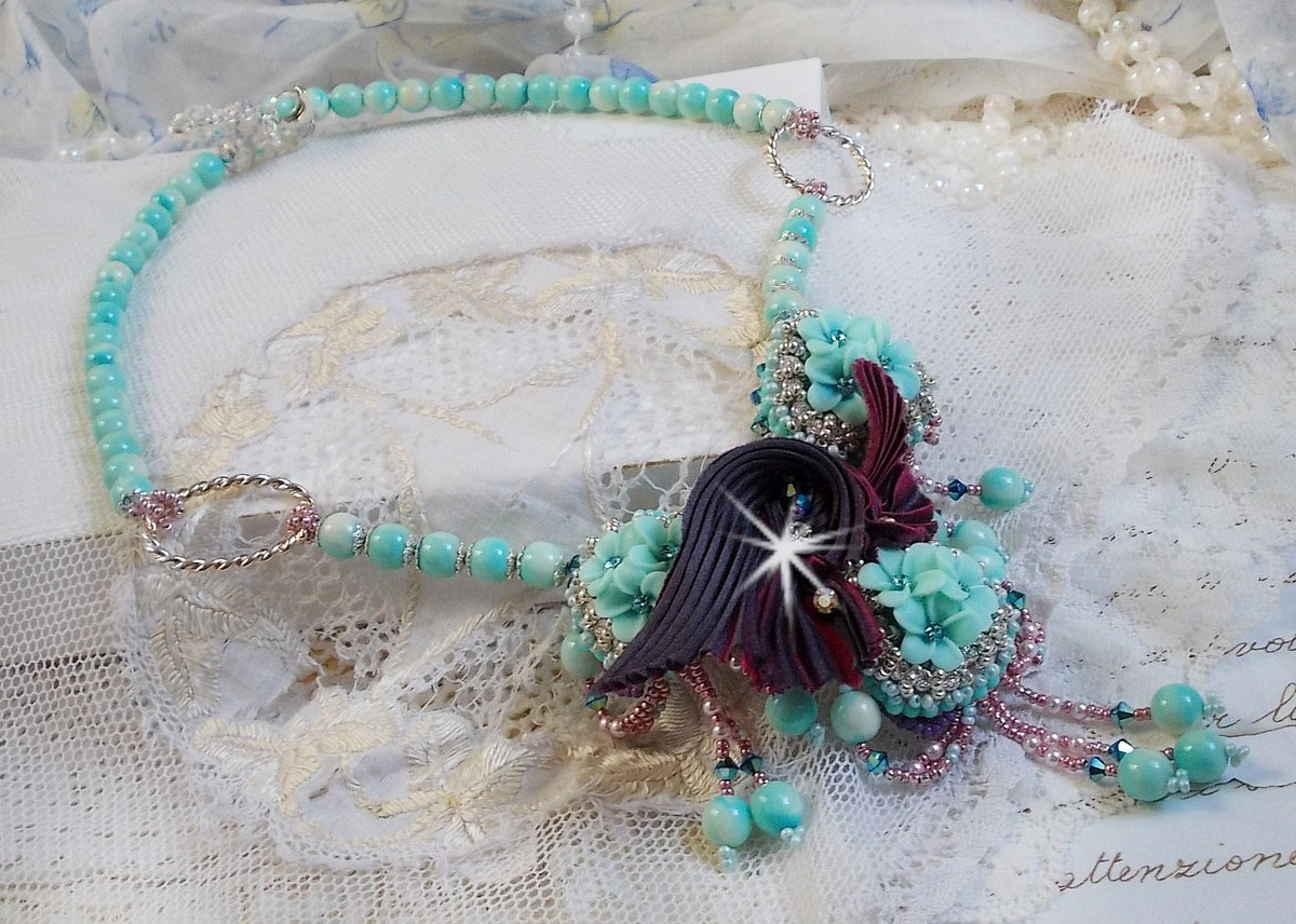 Collier Blue Flowers Haute-Couture brodé avec des Cristaux de Swarovski, un ruban de soie de couleur Truffe/Framboise et des rocailles