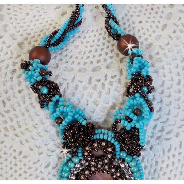 Collier Turquoise Haute Couture au Style Am&eacute;rindien brod&eacute; sur du Cuir avec des cabochons ronds Nacre Acajou et Prune, s&rsquo;ajoute un cabochon Turquoise. Orn&eacute; de cristaux, ruban, perles et rocailles 