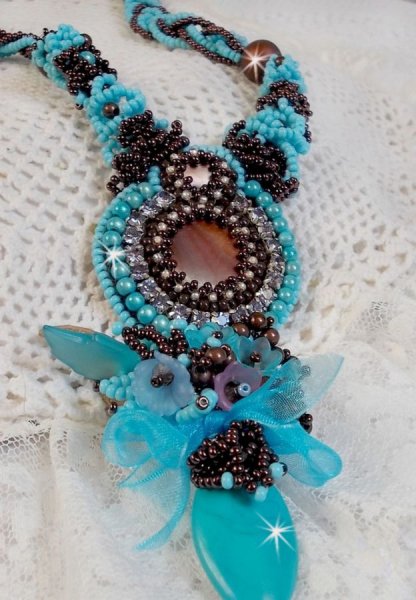 Collier Turquoise Haute Couture au Style Am&eacute;rindien brod&eacute; sur du Cuir avec des cabochons ronds Nacre Acajou et Prune, s&rsquo;ajoute un cabochon Turquoise. Orn&eacute; de cristaux, ruban, perles et rocailles 