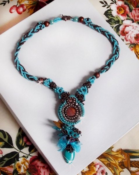 Collier Turquoise Haute Couture au Style Am&eacute;rindien brod&eacute; sur du Cuir avec des cabochons ronds Nacre Acajou et Prune, s&rsquo;ajoute un cabochon Turquoise. Orn&eacute; de cristaux, ruban, perles et rocailles 