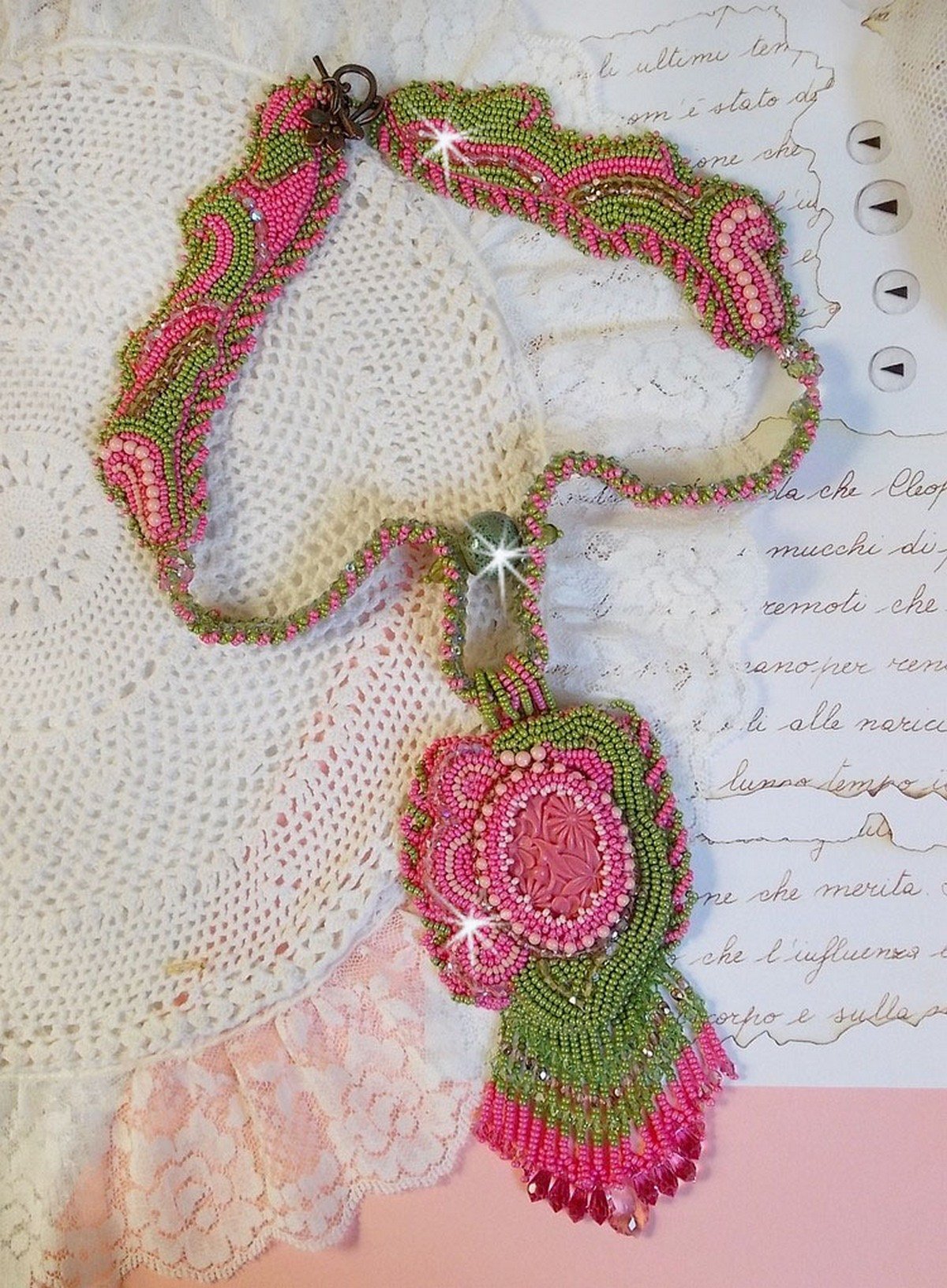 Collier Miss Lady brod&eacute; avec un cabochon repr&eacute;sentant des fleurs de couleur Rose Pink &agrave; laquelle s'ajoute perles rondes, toupies en Cristal, facettes, rocailles Anis, Rose et perle c&eacute;ramique 