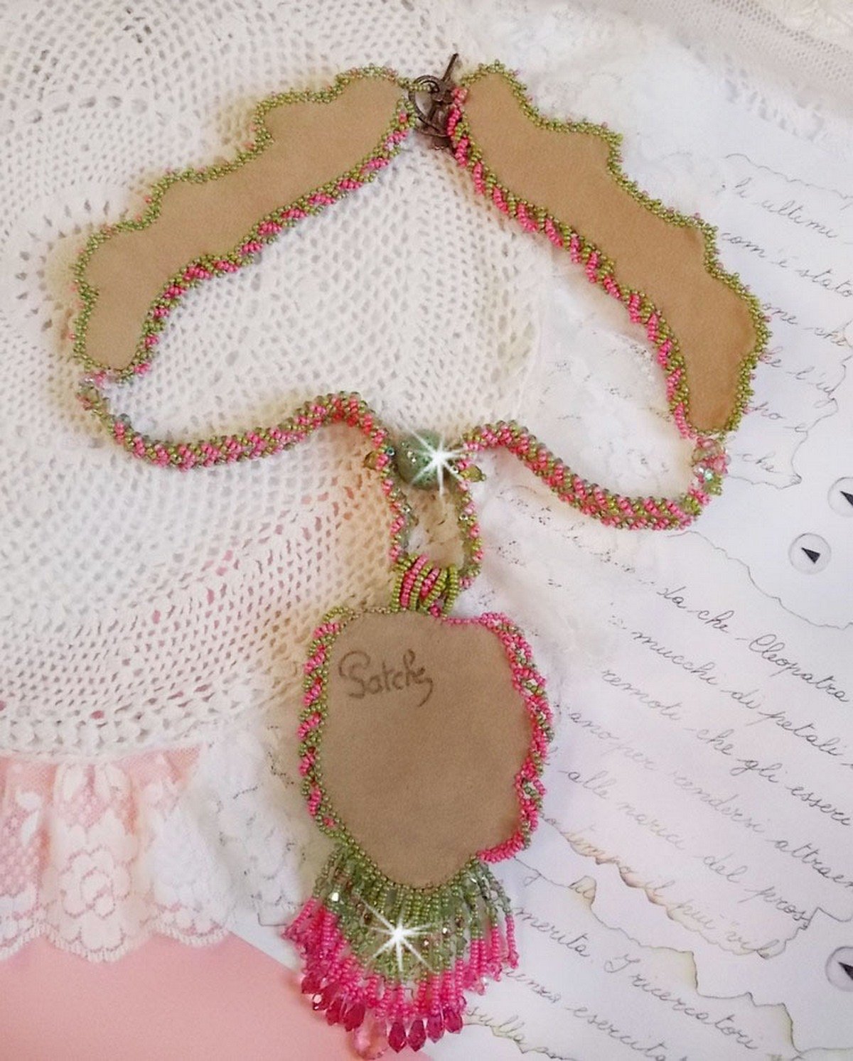 Collier Miss Lady brod&eacute; avec un cabochon repr&eacute;sentant des fleurs de couleur Rose Pink &agrave; laquelle s'ajoute perles rondes, toupies en Cristal, facettes, rocailles Anis, Rose et perle c&eacute;ramique 