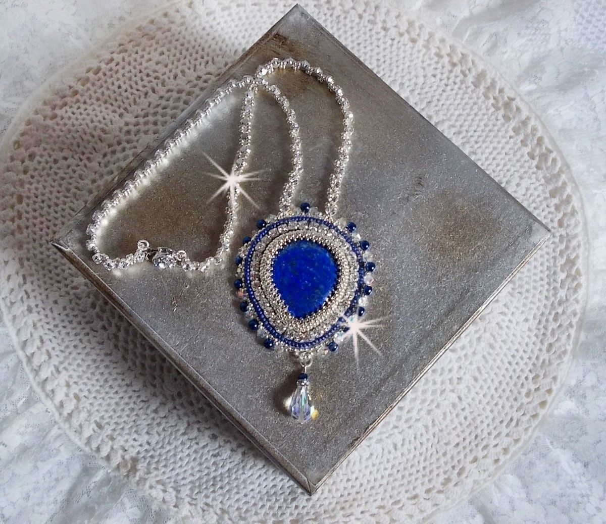 Collier Nil Bleu brodé avec une pierre de gemme : un Lapis Lazuli en forme de poire, cristaux : chatons, gouttes et toupies Cristal, perles rondes nacrées en Verre Bleu Marine et rocailles Argentées
