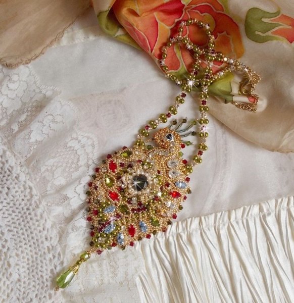 Collier L&rsquo;Oiseau des Iles brod&eacute; fa&ccedil;on Art Nouveau sur une su&eacute;dine avec une estampe o&ugrave; se niche diff&eacute;rents cristaux de tailles et couleurs diff&eacute;rentes, des rocailles Miyuki et des perles Antiques 