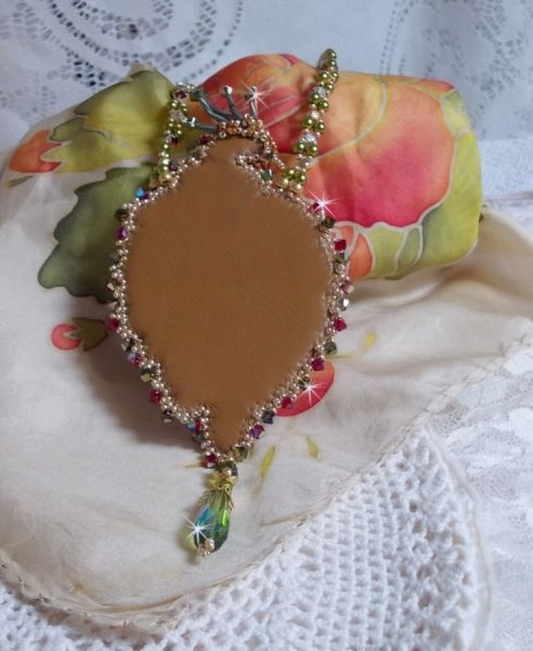 Collier L&rsquo;Oiseau des Iles brod&eacute; fa&ccedil;on Art Nouveau sur une su&eacute;dine avec une estampe o&ugrave; se niche diff&eacute;rents cristaux de tailles et couleurs diff&eacute;rentes, des rocailles Miyuki et des perles Antiques 