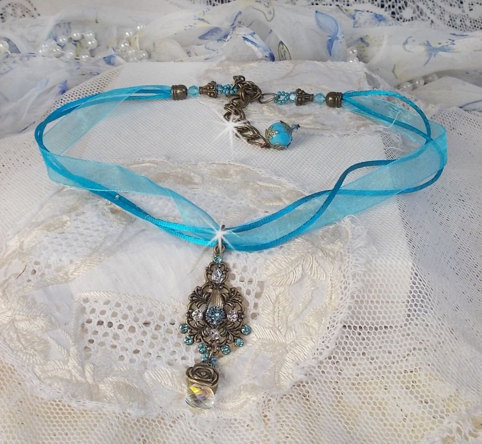Collier pendentif Lady in Blue monté avec des cristaux de Swarovski, des intercalaires fleurs, des coupelles feuillage et des rubans