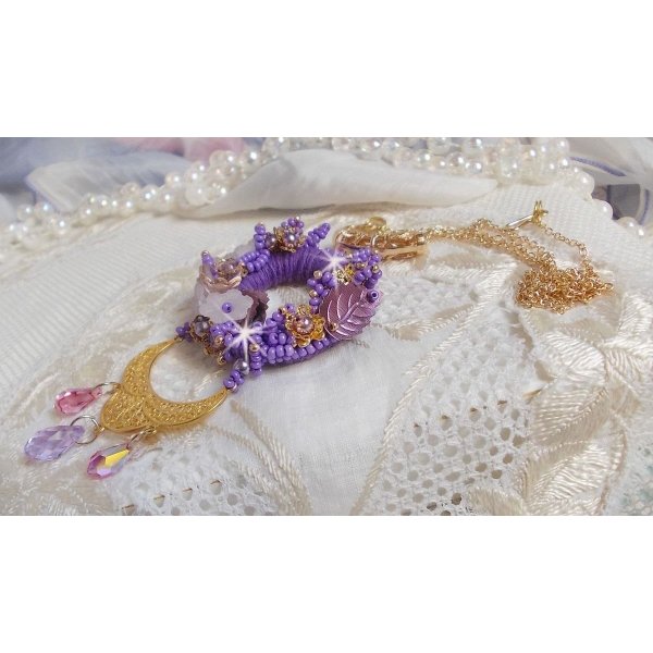 Pendentif Laureline brodé avec un fil coton Violet, monté avec des cristaux, fleurs lucites, perles nacrées, calottes dorées, rocaille, pendentif sur une chaîne en plaqué Or. Un voile de douceur