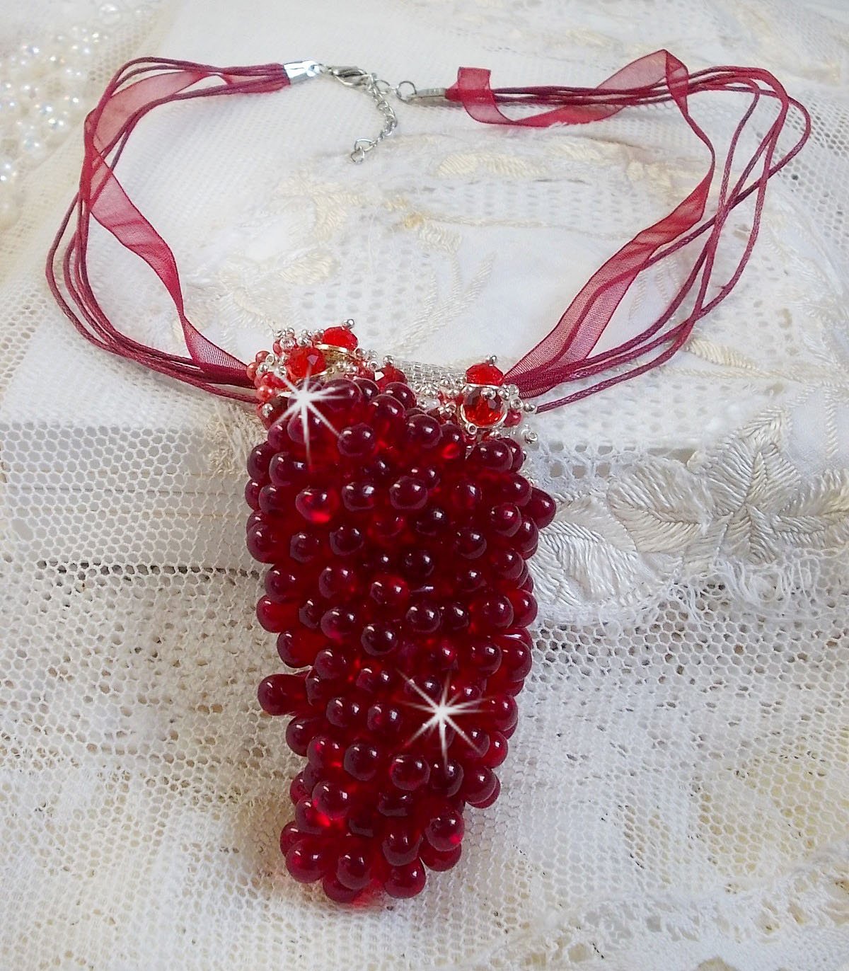 Pendentif Tendre Rouge mont&eacute; avec des gouttes en verre rouge, des perles rondes facett&eacute;es et des perles nacr&eacute;es