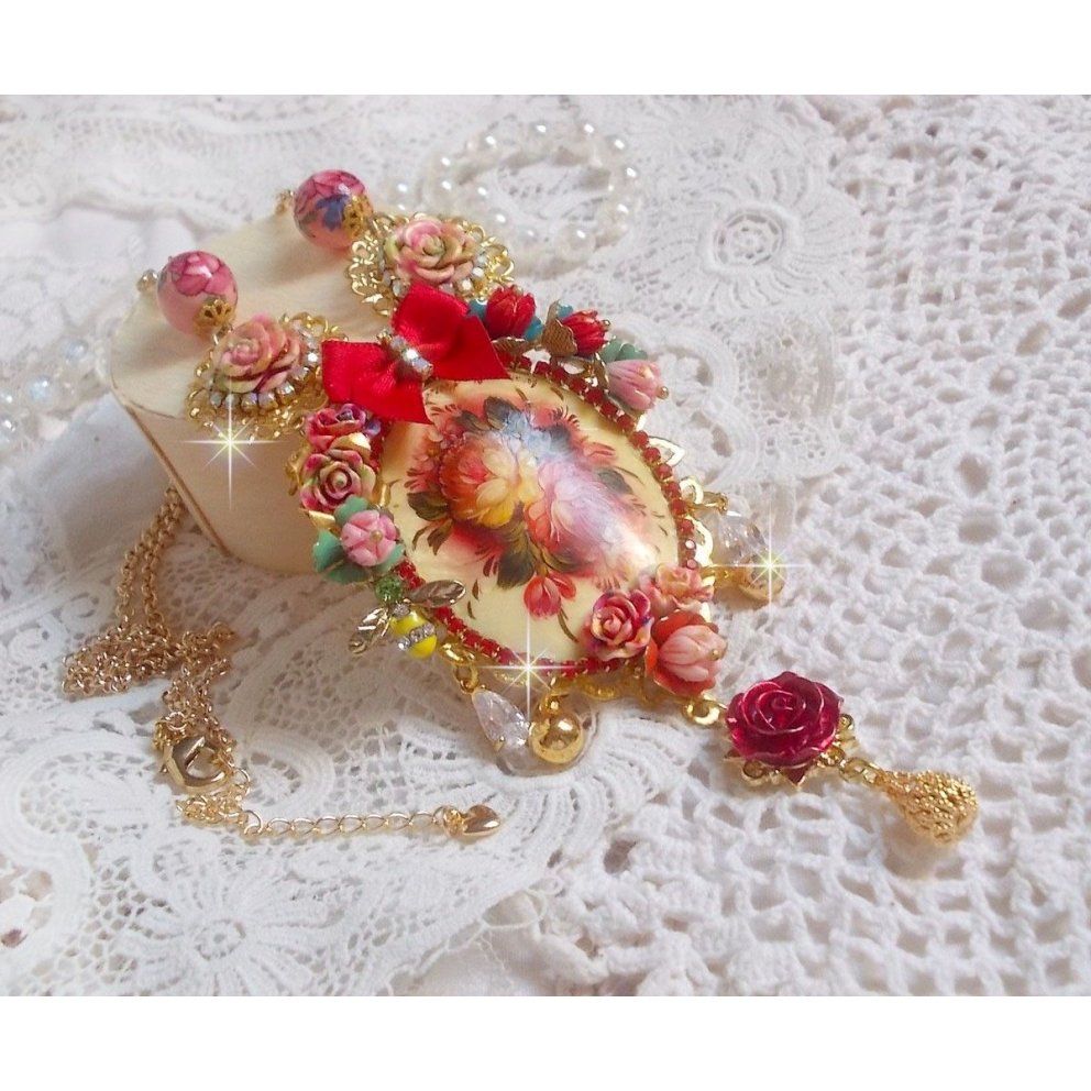 Collier Roseraie Provençale crée avec des perles en verre, céramique, résine, des accessoires en plaqué Or et autres avec un nœud en satin Rouge