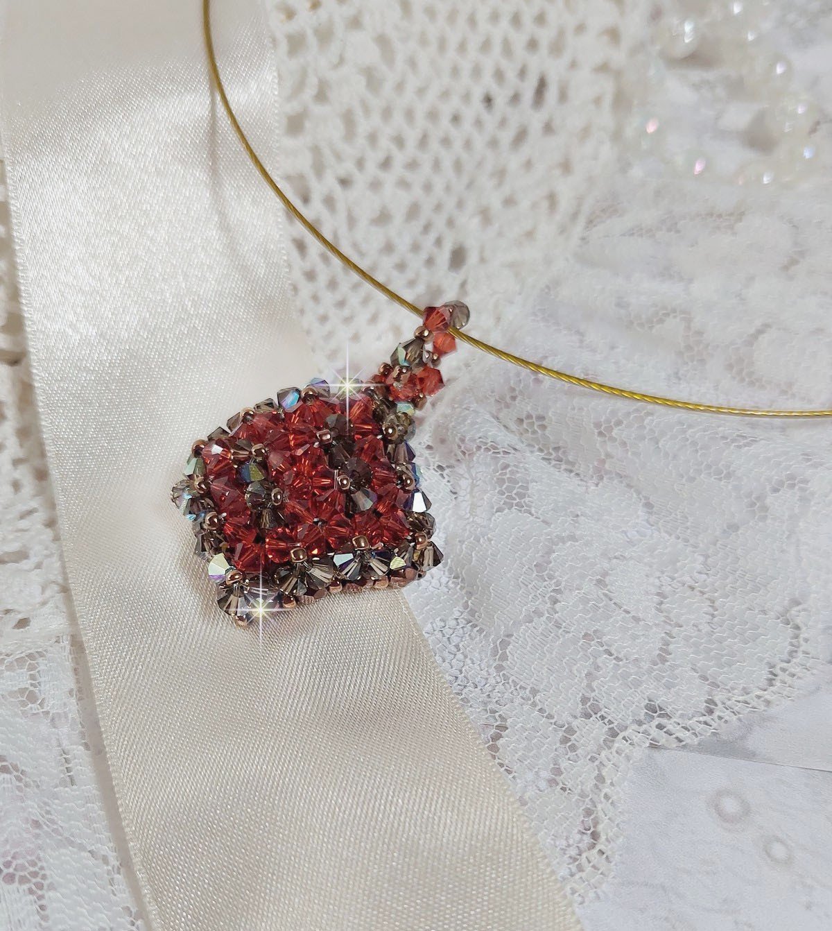 Pendentif Camel mont&eacute; avec des toupies en cristal Indian Red et Smoked Topaz de qualit&eacute; AB sur une base de facettes Dark Bronze et sur un tour de cou c&acirc;bl&eacute; rigide Dor&eacute; avec un fermoir &agrave; vis Argent&eacute;