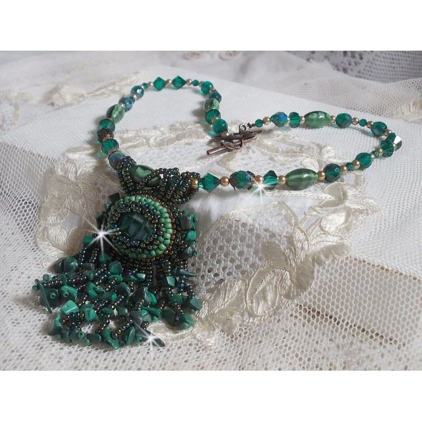 Pendentif Emerald avec un cabochon ovale en Malachite orn&eacute; de chips avec cristaux : perles rondes et toupies Emerald. S&rsquo;ajoute des perles en forme d&rsquo;olives. Brod&eacute;s sur fermoir en T. Un style Ethnique