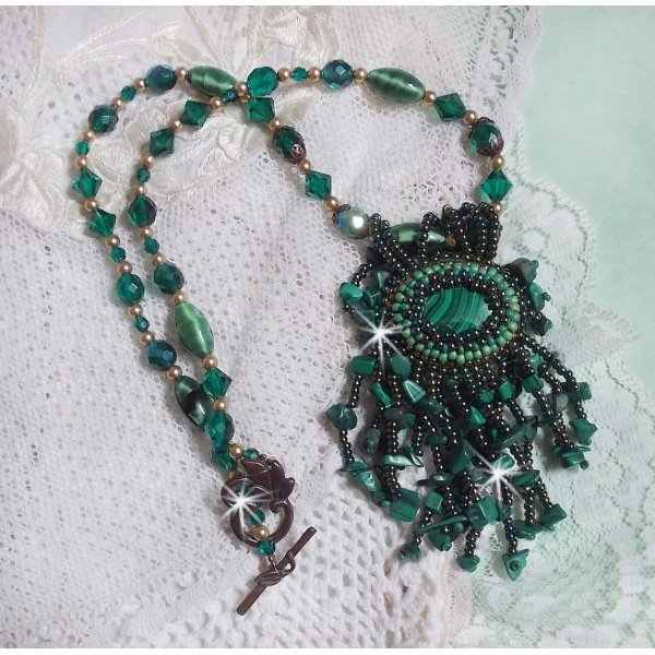 Pendentif Emerald avec un cabochon ovale en Malachite orn&eacute; de chips avec cristaux : perles rondes et toupies Emerald. S&rsquo;ajoute des perles en forme d&rsquo;olives. Brod&eacute;s sur fermoir en T. Un style Ethnique