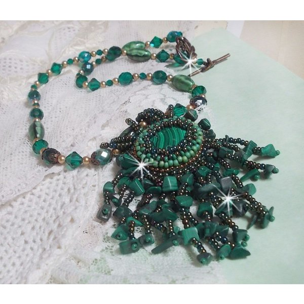 Pendentif Emerald avec un cabochon ovale en Malachite orn&eacute; de chips avec cristaux : perles rondes et toupies Emerald. S&rsquo;ajoute des perles en forme d&rsquo;olives. Brod&eacute;s sur fermoir en T. Un style Ethnique