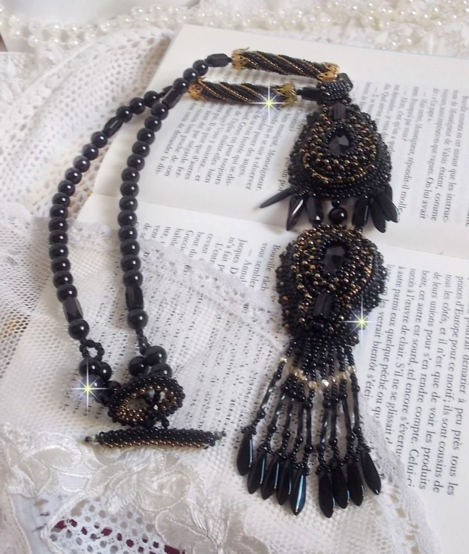 Pendentif Habit Noir pour un style Vintage est brodé avec une pierre de Gemme : l’Onyx Noir à laquelle s’ajoute des cristaux, dagues, perles, facettes et rocailles en Verre. Belle harmonie !
